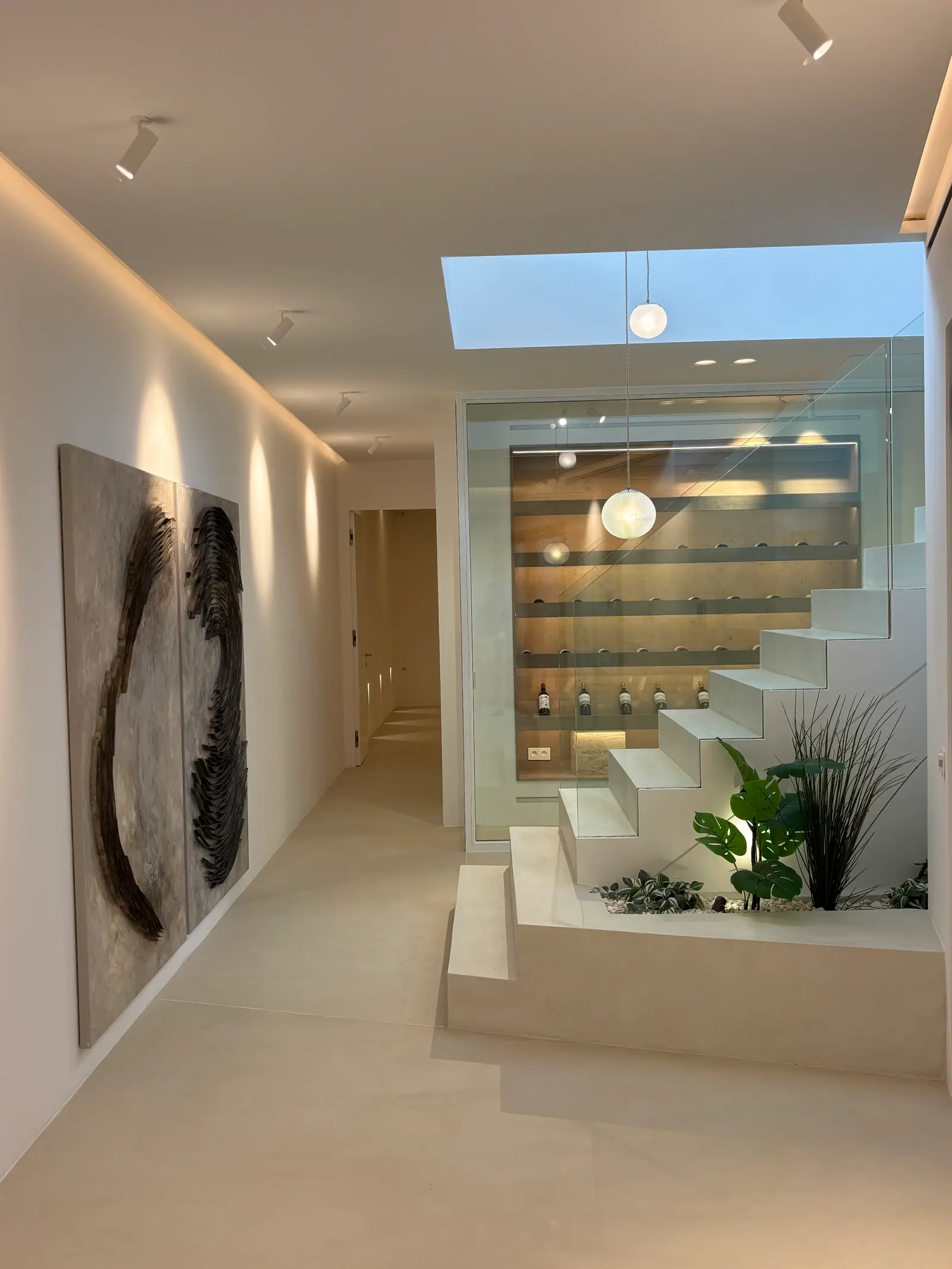 Gallery hallway with artwork, staircase and glazed wine cellar