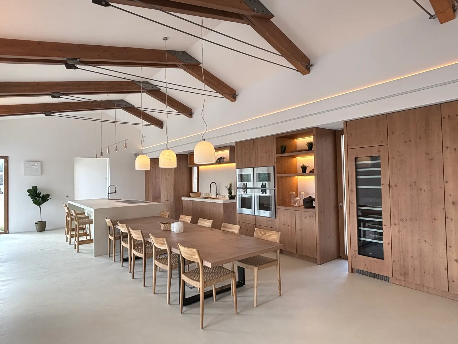 Living kitchen with long dining table and wine cabinet