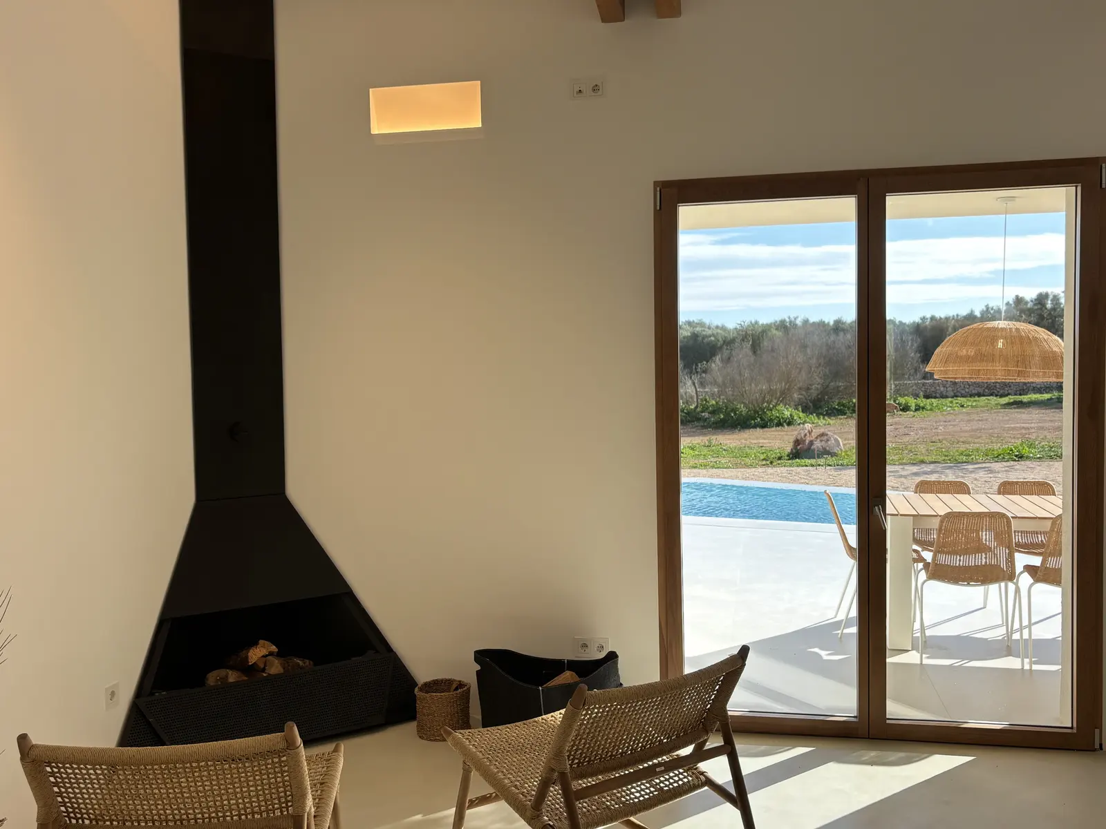 Living room with sculptural fireplace and view to pool and terrace