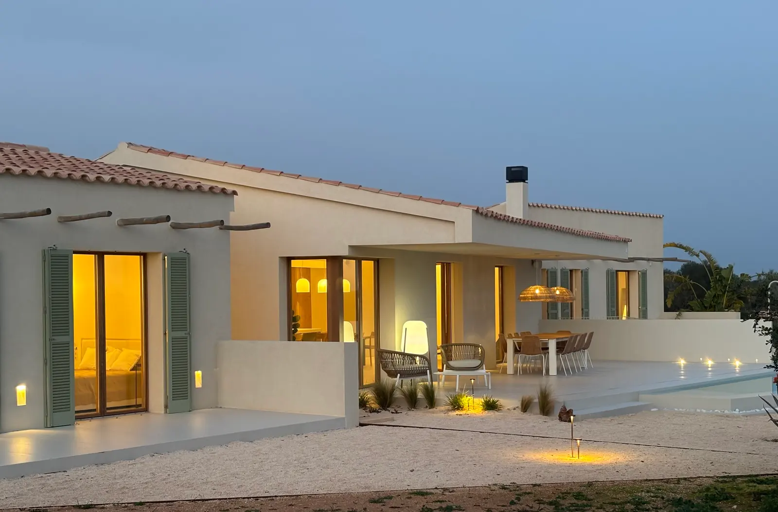 Warmly lit terrace and pool side at blue hour