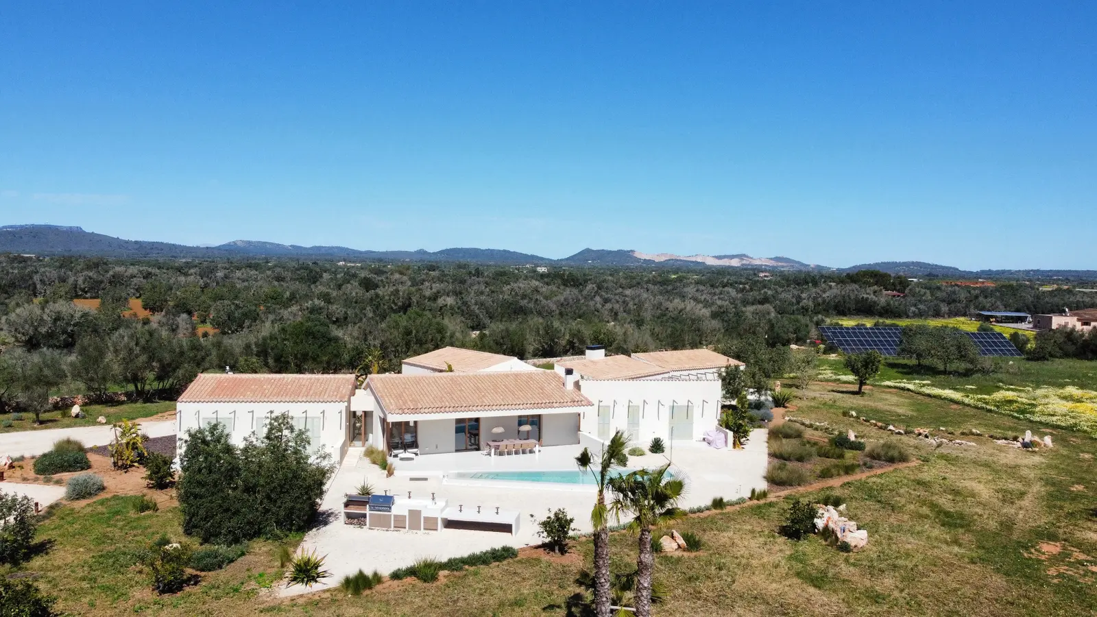 Aerial view of the finca with pool, olive grove and solar field