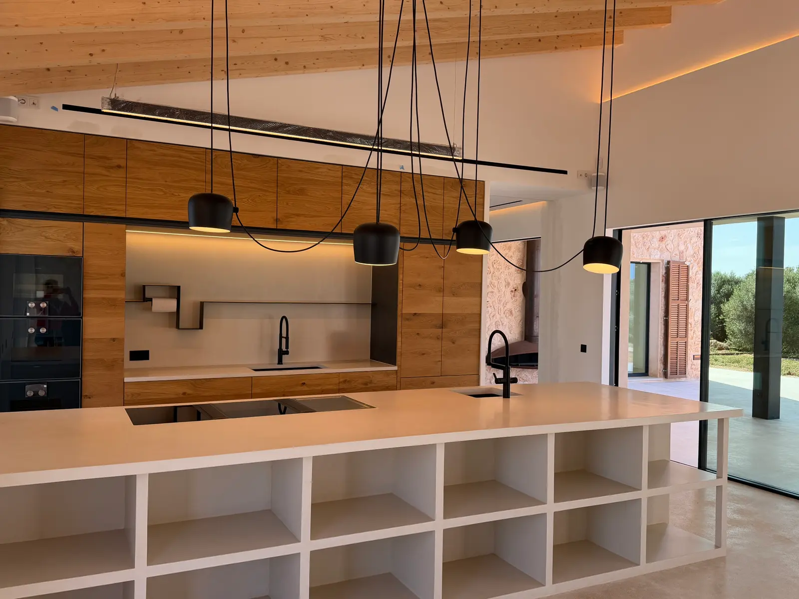 Open kitchen with island under timber beam ceiling